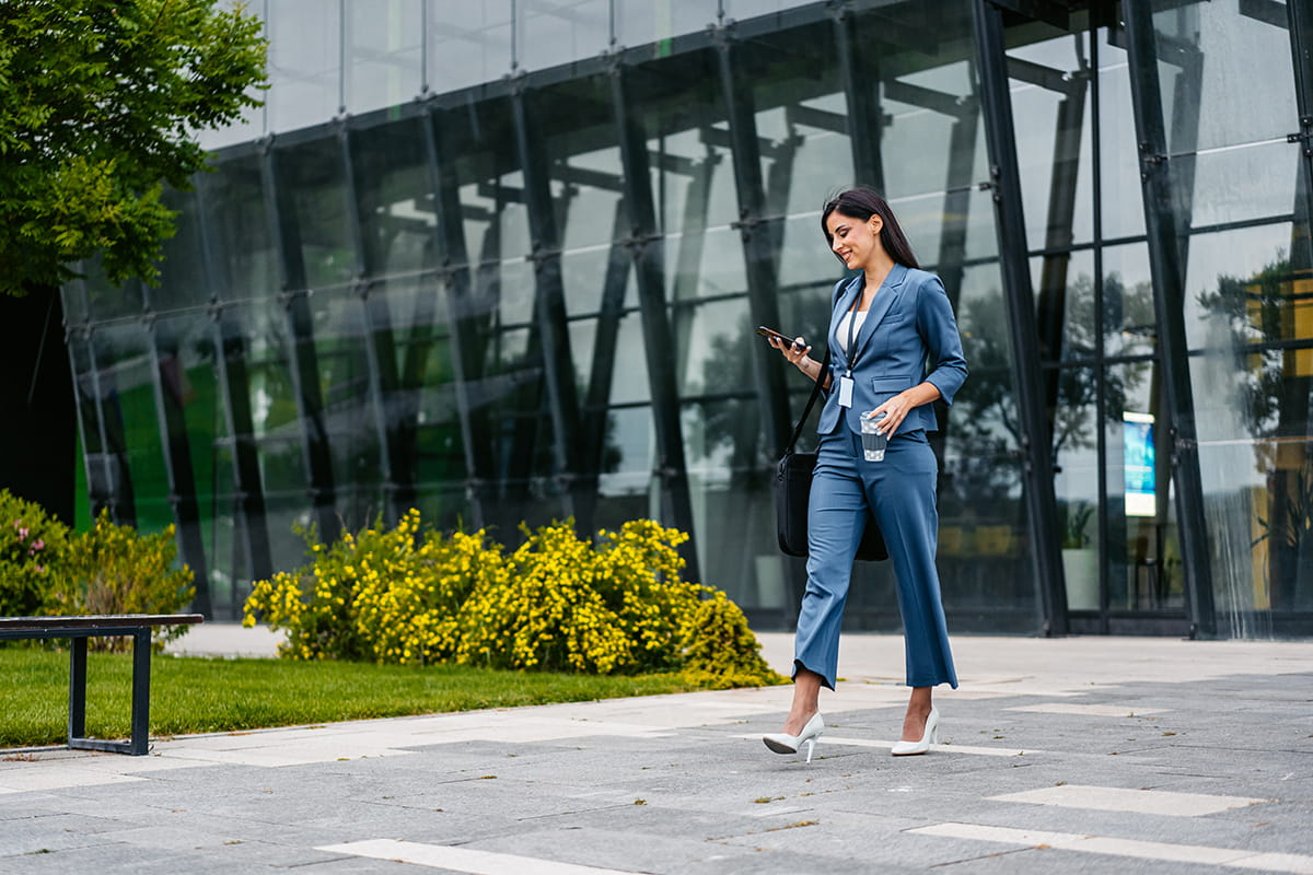 Business woman walking while on phone