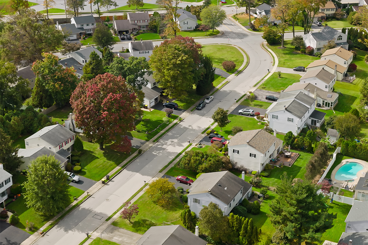 aerial view of neighborhood street with houses lining it