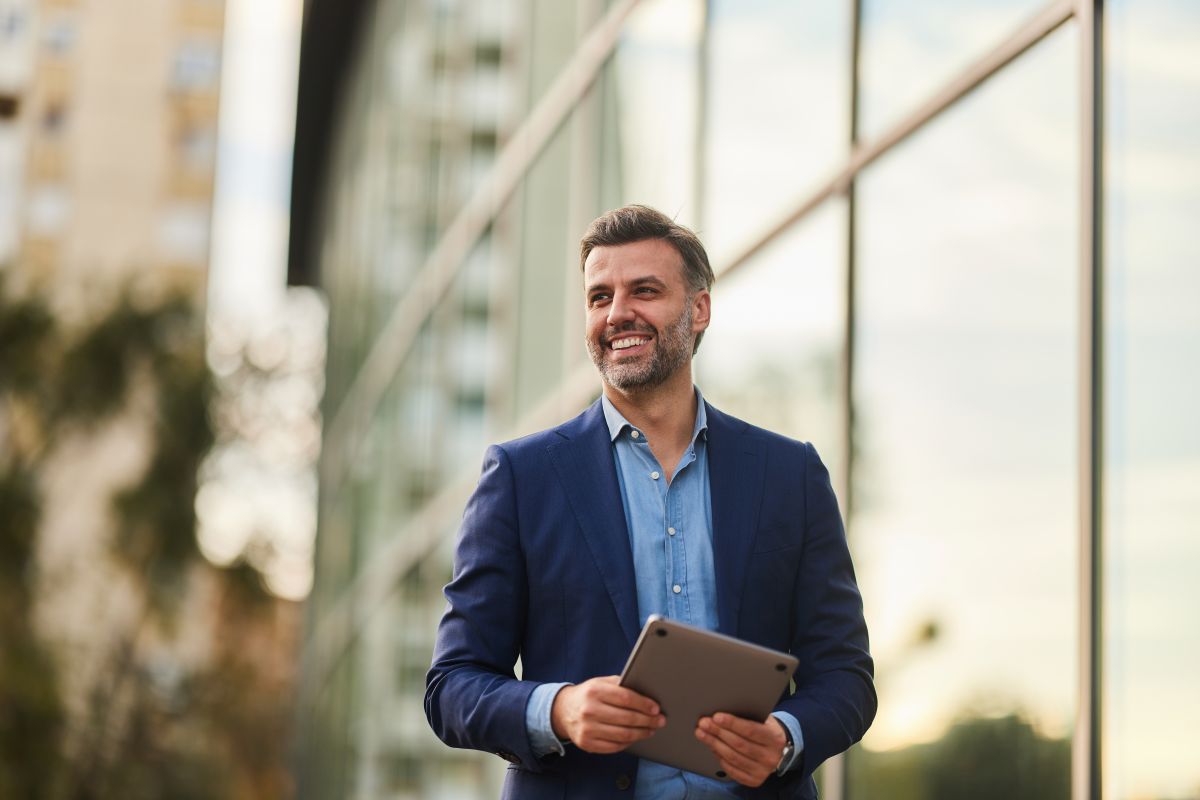 Man outside walking with laptop 